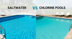A high-quality, professional, featured image for a blog post comparing saltwater and chlorine pools. The image shows two pools side-by-side, one with sparkling blue water indicating chlorine, and the other with a slightly more turquoise hue, suggesting saltwater. Both pools are surrounded by lush green landscaping and inviting lounge chairs. The composition is well-balanced, with the pools as the focal point. Natural sunlight illuminates both scenes, showcasing the difference in water clarity and the vibrant surroundings. A subtle vignette adds a touch of drama, drawing the viewer's attention to the central theme of pool maintenance and the unique qualities of each pool type. This featured image will be compelling and informative, immediately engaging the readers and encouraging them to explore the blog post to discover the advantages and disadvantages of saltwater vs. chlorine pools.
