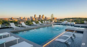 Buffalo pool remodeling trends. Shows a modern, renovated pool with new lighting and a stylish deck, with the Buffalo skyline in the background.